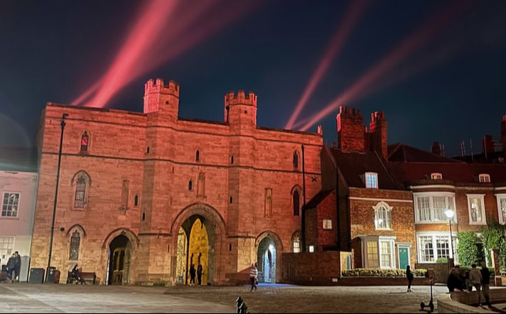 Night picture of the Exchequer Gate in Lincoln illuminated for Halloween